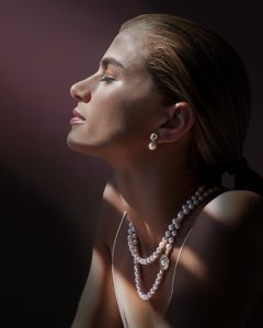 a woman with a necklace and pearls on her neck