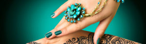 a woman's hand with blue and green nail polish