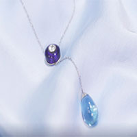 a necklace with a blue stone and a silver ball