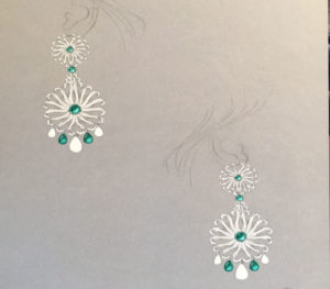 a pair of green and white earrings on a table
