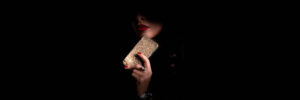 a woman holding a gold purse in the dark