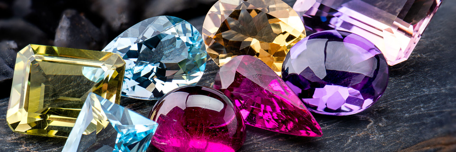 five different colored diamonds sitting on top of a wooden table
