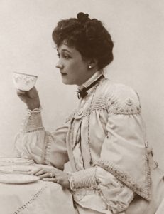 a woman sitting at a table with a cup in her hand