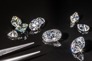 a group of diamond cut diamonds next to a pair of scissors