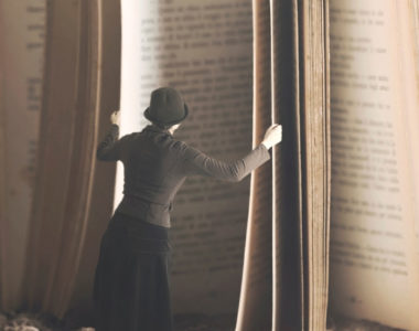 a woman standing in front of an open book