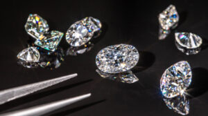 a group of diamond cut diamonds next to a pair of scissors