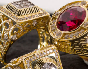 two gold rings with red and white stones