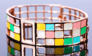 a colorful bracelet is shown on a reflective surface