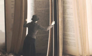 a woman standing next to an open book