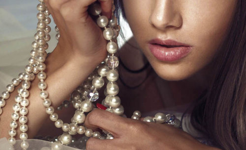 a woman is holding some pearls in her hands