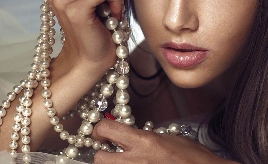 a woman is holding some pearls in her hands