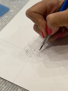a person is drawing on paper with a pen