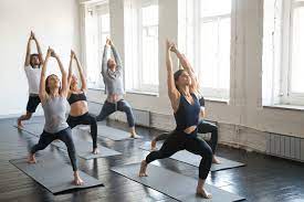 a group of people doing yoga poses in a room