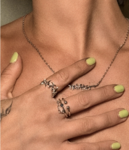 a woman with green nail polish holding her hands on her chest