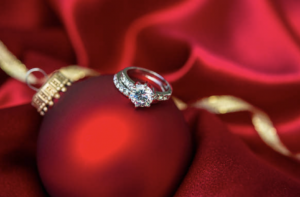 a red ornament with two wedding rings on it