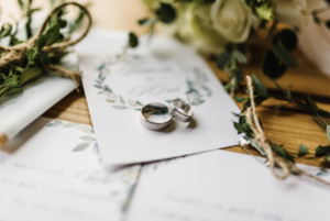 two wedding rings on top of a table next to flowers